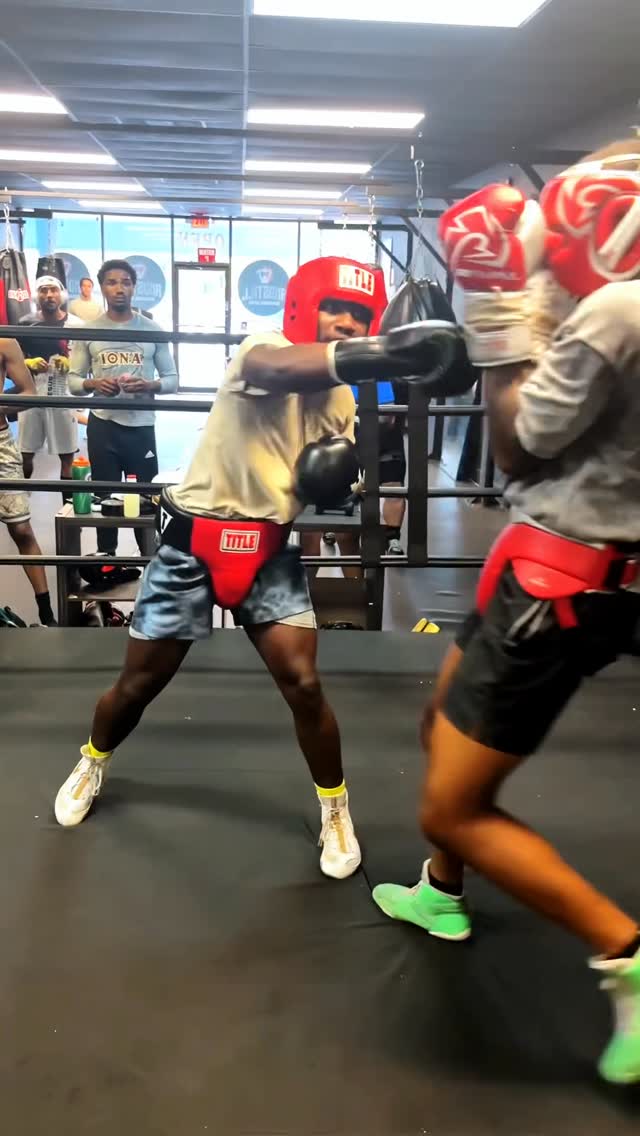 Kenneth Sene sparring in headgear inside a training gym