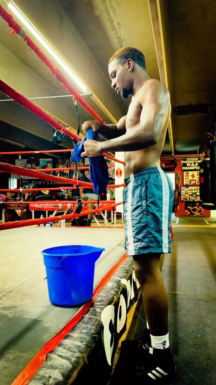 Kenneth Sene getting ready in the corner of a ring with red ropes
